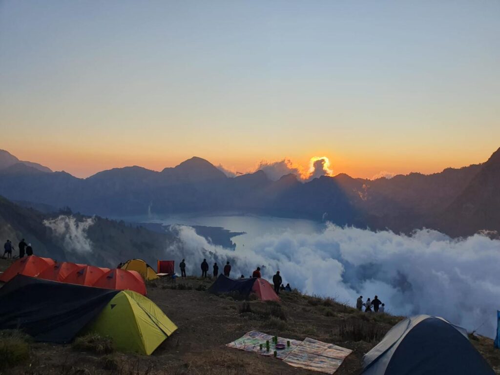 Beautiful sunrise view during Rinjani trekking from the crater rim campsite overlooking Segara Anak Lake, Mount Rinjani Lombok Indonesia