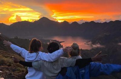 Trekkers enjoying a beautiful sunrise view during Rinjani trekking overlooking Segara Anak Lake at Mount Rinjani Lombok Indonesia